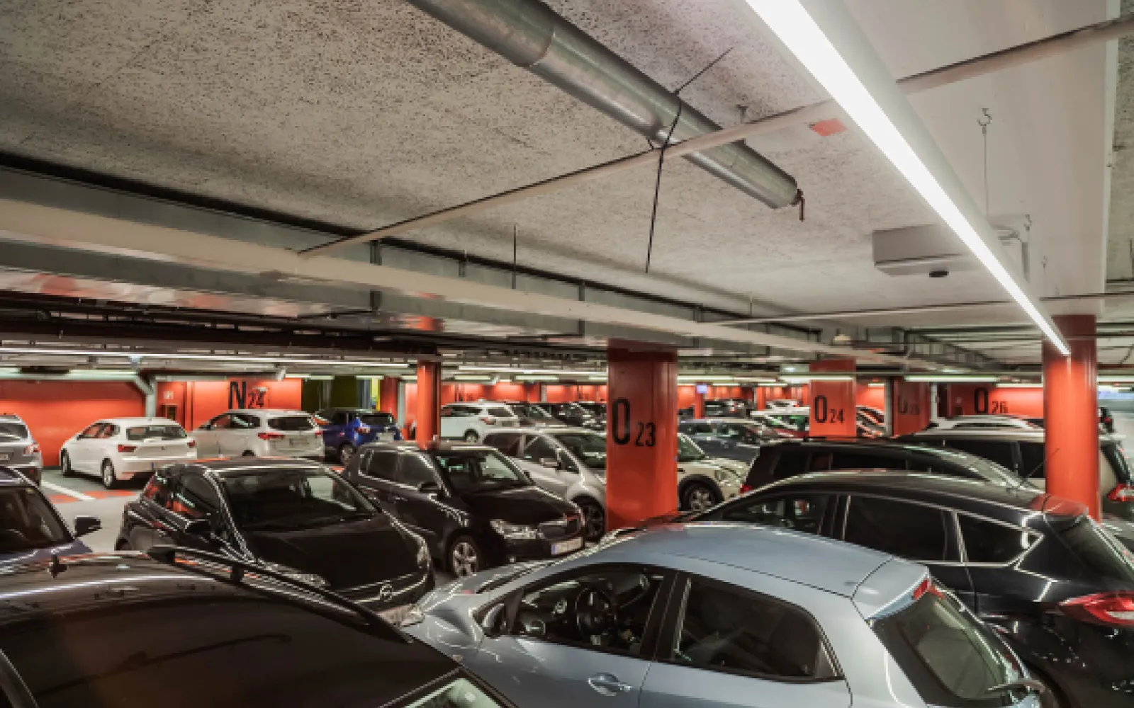 Nummerierte Stellplätze einer Tiefgarage unter LED-Leuchten